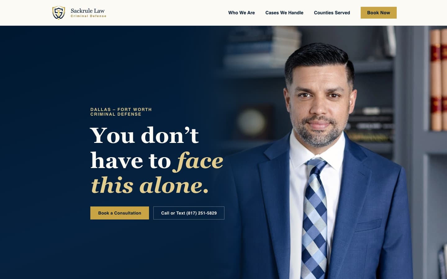 Sackrule Law home page on a desktop screen: a navy hero with attorney Wes Sackrule in a blue suit, the headline You don't have to face this alone, and buttons to book a consultation or call.
